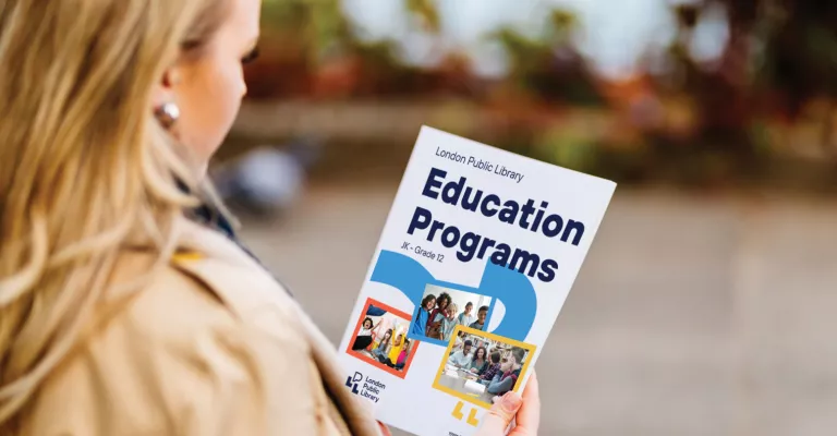 Woman holding an education and programs pamphlet