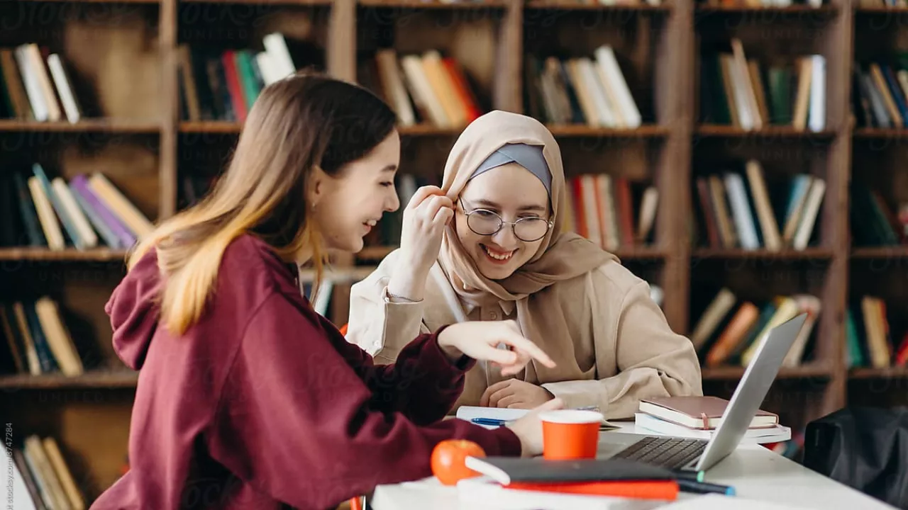  two students sitting in library together