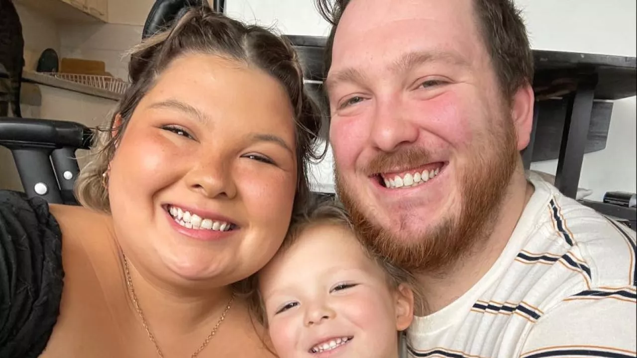 Photo of illustrator Bridget George, her young child and her husband smiling.