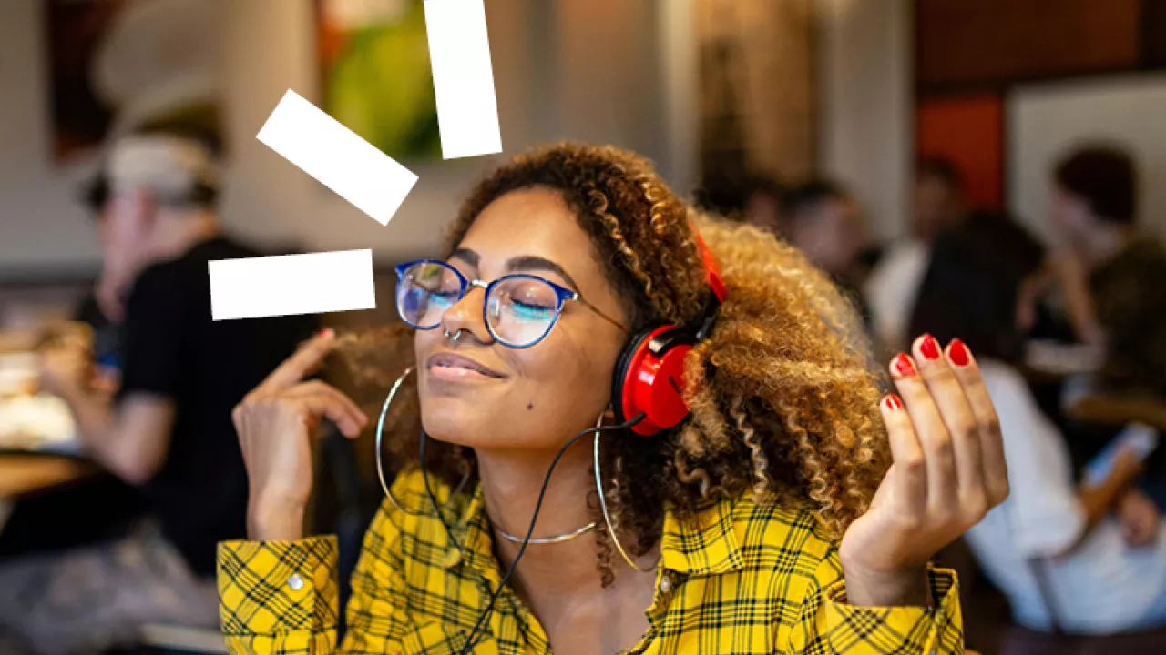 Photo of a young woman listening with headphones on and closing her eyes