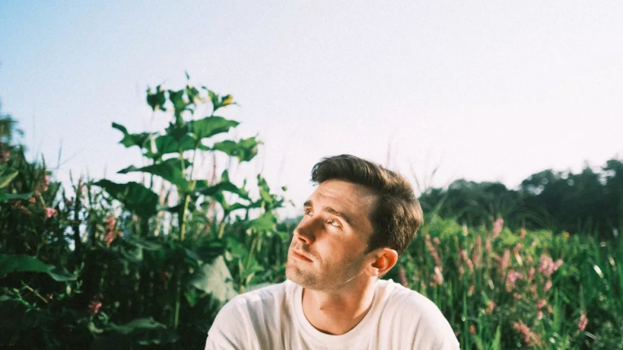 John Muirhead outdoors in a field looking up to the sky