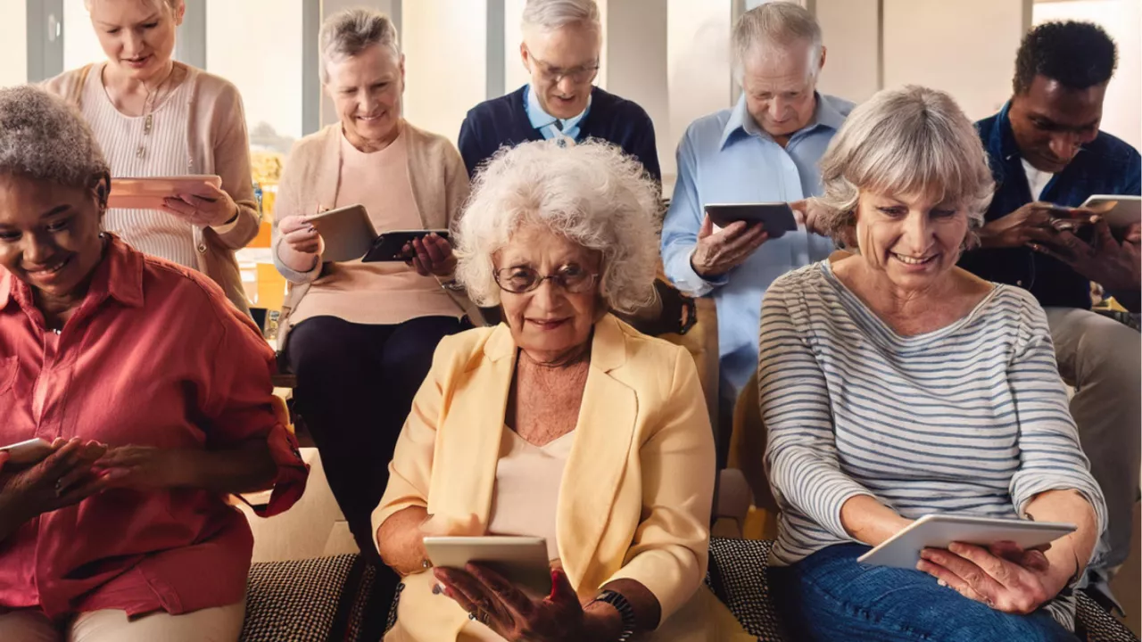 A group of senior citizens using tablets and phones