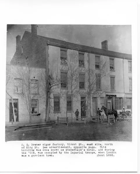 Black and white image of people and a horse in front of a building