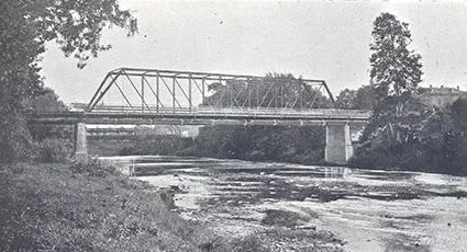 Black and white photo of a bridge over a river